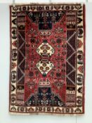 A Caucasian style red ground rug, 164 x 115cm