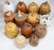 Thirteen various pottery honey jars and covers