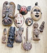 Eight Yoruba carved wood tribal figures, terracotta vessel, Ceylonese painted wood mask, East Java