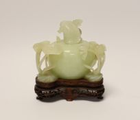 A Chinese carved bowenite jade ‘lotus’ water pot and cover on hardwood stand, 13cm