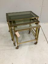 A nest of three rectangular mid century brass tea tables with smoked glass tops, width 53cm, depth