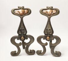 A pair of Art Nouveau cast iron and embossed copper fire dogs, 33cm high
