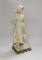 An alabaster carved figure of a girl holding a basket, 51cm high