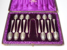 A cased set of twelve Victorian engraved silver rat tail pattern teaspoons with sugar tongs,