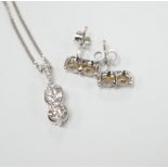 A modern 14k gold and two stone diamond set pendant, with diamond chip set bale, on a 14k gold