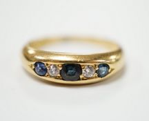 A George V 18ct gold, three stone sapphire and two stone diamond set half hoop ring, size N, gross