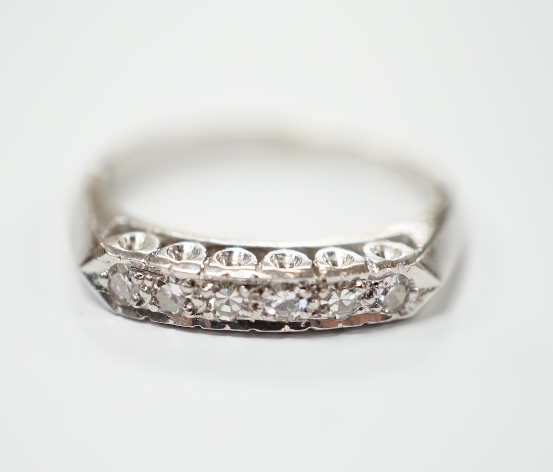 A 14k white metal and six stone diamond chip set half hoop ring, size L, gross weight 2.6 grams.