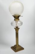 A Victorian brass oil lamp with glass reservoir and etched shade, 70cm high