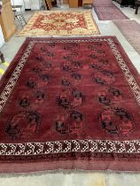 An Afghan red ground carpet, 380 x 243cm