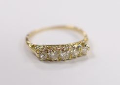 An early 20th century yellow metal and graduated five stone old round diamond set half hoop ring,