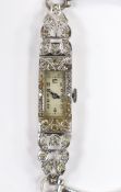 A lady's white metal stamped (All Platinum) and diamond cluster set manual wind cocktail watch, on a