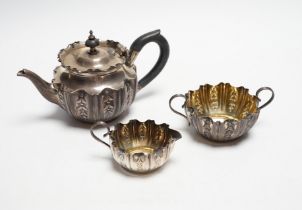 A late Victorian bachelor's repousse silver three piece tea set, Sheffield, 1894/5, gross 11.3oz.