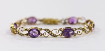 An early 20th century 9ct, amethyst and seed pearl cluster set bracelet, with carved barrel shaped