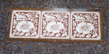A Victorian carved oak stand inset with there floral tiles, 69cm wide