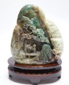 A Chinese jadeite boulder carving on hardwood stand, 17cm high