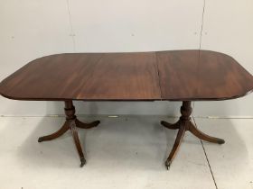 A George III and later mahogany twin pillar extending dining table, 176cm extended, one spare