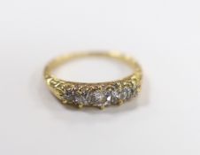 An early 20th century yellow metal and graduated five stone diamond set half hoop ring, size I,