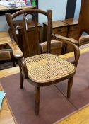An early 20th century Thonet bentwood beech child’s elbow chair with cane seat.