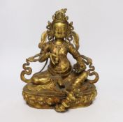 A large Sino-Tibetan gilt bronze seated figure of Jambhala, 28cm high