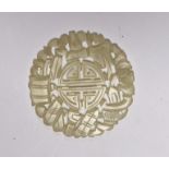 A Chinese carved disc, possibly jade, 5.5cm in diameter