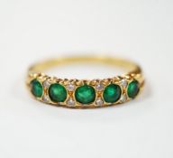 A modern 18ct gold and five stone emerald set half hoop ring, with diamond chip spacers, size K/L,
