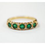 A modern 18ct gold and five stone emerald set half hoop ring, with diamond chip spacers, size K/L,