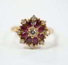 An 18ct, ruby and diamond set flower head cluster ring, size K, gross weight 3.7 grams.
