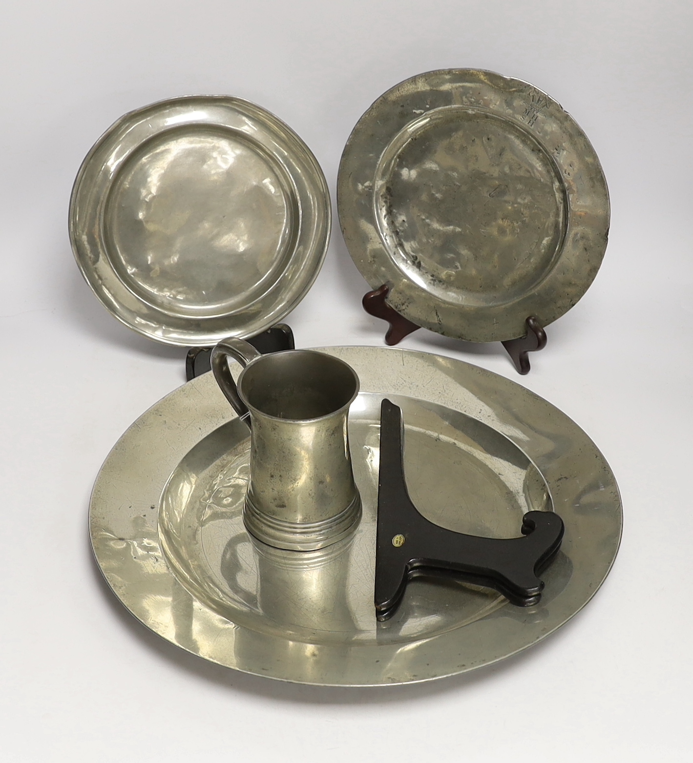 Four 18th century and later pewterware items including a charger, 41.5cm diameter, two plates, and a