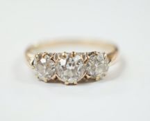 A yellow metal and three stone diamond set ring, size P, gross weight 2.6 grams.
