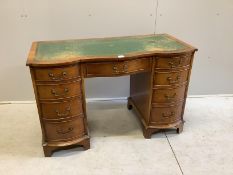 A reproduction walnut serpentine kneehole desk, width 115cm, depth 53cm, height 75cm