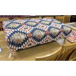 A large contemporary rectangular footstool upholstered in Kilim style polychrome fabric on turned