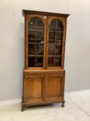 An early 20th century Jacobean Revival oak bookcase cupboard, width 84cm, depth 31cm, height 175cm