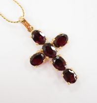 A modern 750 yellow metal and six stone oval cut garnet set cross pendant, 38mm, gross weight 3.5