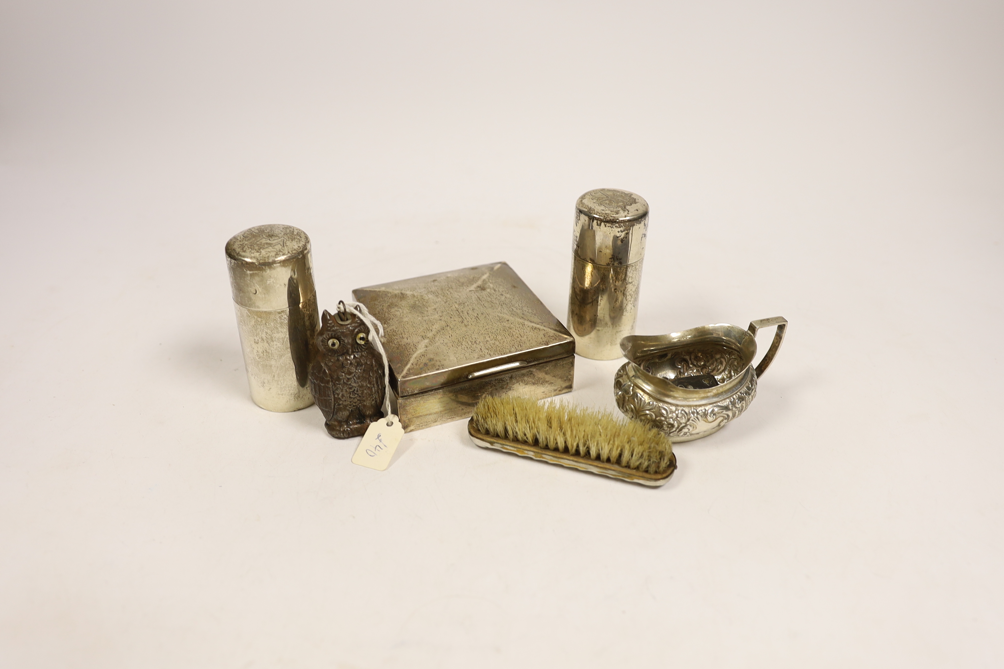 A late Victorian embossed silver cream jug, a pair of silver toilet bottles, a silver backed