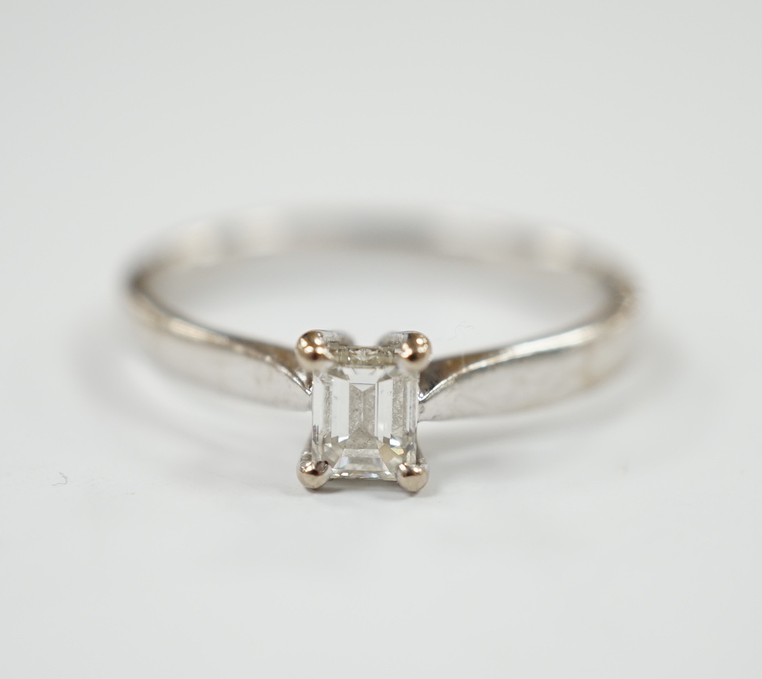 A modern 18ct white gold and solitaire emerald cut diamond set ring, size Q, gross weight 3.4