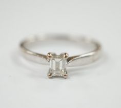 A modern 18ct white gold and solitaire emerald cut diamond set ring, size Q, gross weight 3.4