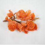 A yellow metal mounted carved coral floral spray brooch(a.f.), 64mm.