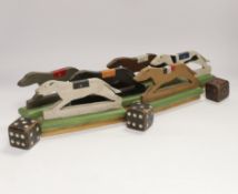 A painted wood greyhound racing game and three wooden dice, 19cm wide