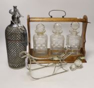An oak three bottle tantalus, a German 800 standard white metal bottle cage and a vintage soda