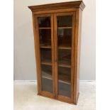 An early 20th century oak and mahogany narrow bookcase with later plinth foot, width 78cm, depth