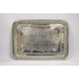 A Persian? engraved white metal tea tray, with embossed foliate border, 42cm, 46.4oz.