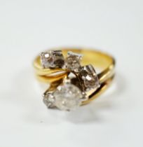 A yellow metal and graduated five stone diamond cluster set dress ring, in a raised setting, size