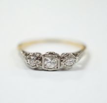 An 18ct, plat and three stone diamond set ring, size N/O, gross weight 2.1 grams.