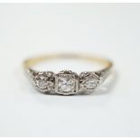 An 18ct, plat and three stone diamond set ring, size N/O, gross weight 2.1 grams.