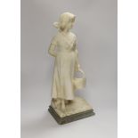 An alabaster carved figure of a girl holding a basket, 51cm high