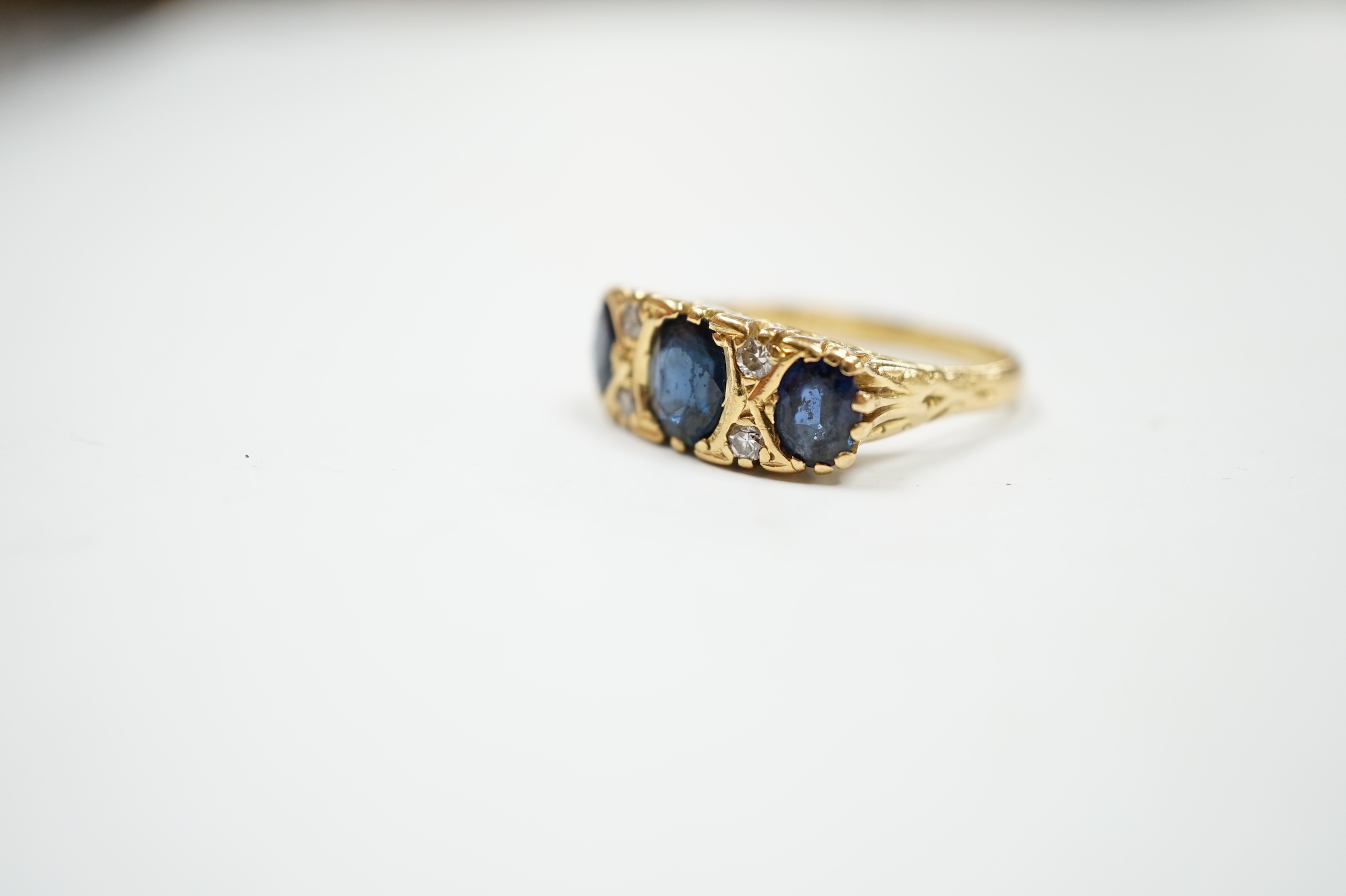 An 18ct and three stone sapphire set half hoop ring, with diamond chip spacers, size O, gross weight - Image 2 of 4