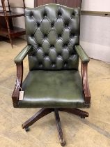 A reproduction mahogany and buttoned green leather swivel desk chair, width 60cm, depth 58cm, height