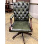 A reproduction mahogany and buttoned green leather swivel desk chair, width 60cm, depth 58cm, height