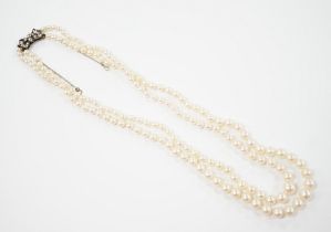 A double strand graduated cultured pearl necklace, with paste set white metal clasp, 44cm.