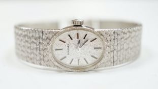 A lady's late 1950's 9ct. white gold Longines manual wrist watch, with integral 9ct white gold